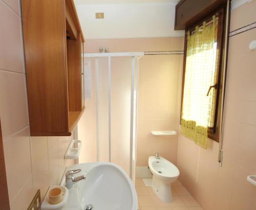a bathroom with a white sink and a toilet at Villa Gloria appartamento E02 in Rosolina Mare