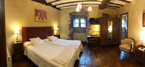 a bedroom with a large white bed in a room at Casa Rural Zigako Etxezuria in Ziga