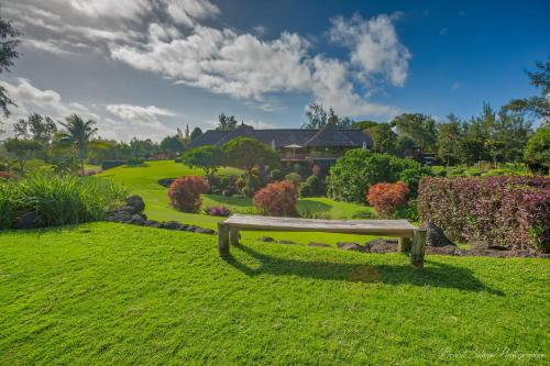 a bench sitting in the grass in a park at Bubble Lodge Ile aux Cerfs Island in Ile aux Cerfs
