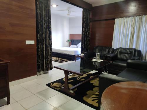 a living room with a couch and a bed at Hotel The Galaxy in Mirzāpur