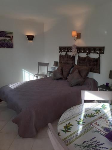 une chambre avec un grand lit et une table dans l'établissement LA CIGALINE, à Lorgues