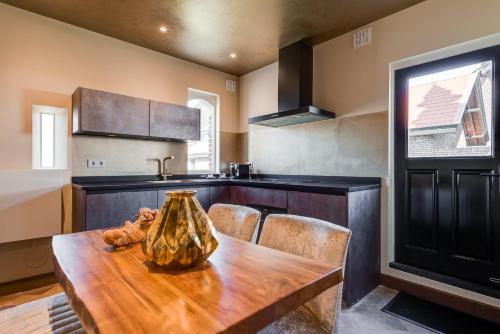 a kitchen with a wooden table with a vase on it at Poortgebouw Kasteel Borgharen - Maastricht in Maastricht