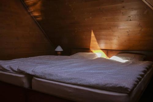 Posto letto in camera con soffitto in legno. di Bora Bora na Slnečných jazerách a Senec