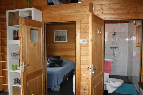 a small room with a bed and a bathroom with a toilet at Cottage Nieuwkoop in Nieuwkoop