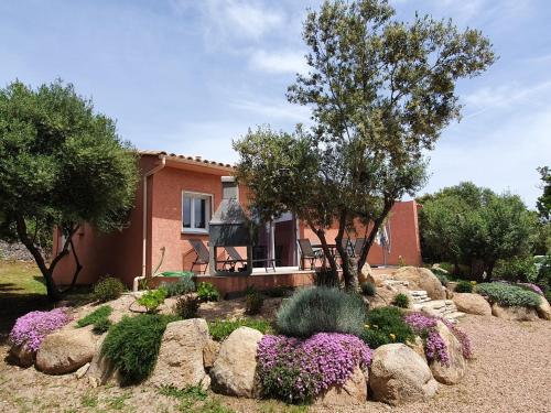 ein Haus mit einem Garten mit Blumen und Steinen in der Unterkunft Mini-villas Célia à BONIFACIO in Bonifacio