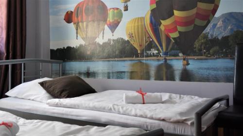 a bedroom with a bed with a painting of hot air balloons at Explorer Hostel & Apartment Stare Miasto OLD TOWN 24H in Poznań