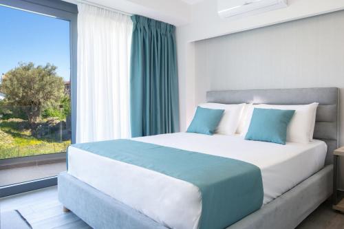 a bedroom with a large bed with a large window at KN Ionian Suites in Nikiana