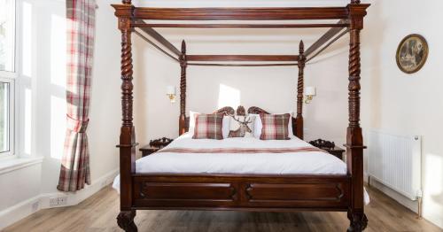a bedroom with a four post canopy bed at The Claymore Guest House in Pitlochry