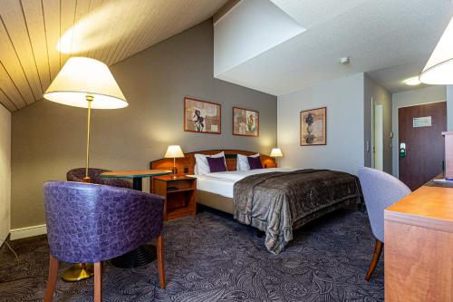 ein Hotelzimmer mit einem Bett und einem Schreibtisch in der Unterkunft Hotel Münchwilen in Wil