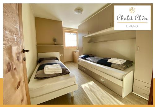 twee bedden in een kleine kamer met een deur bij Chalet Clida in Livigno