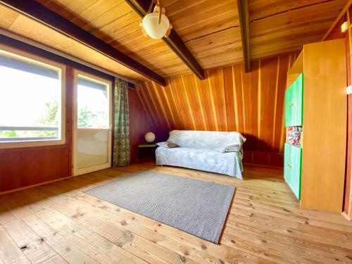 ein Schlafzimmer mit einem Bett in einem Zimmer mit Holzwänden in der Unterkunft Dom Nad Jeziorem Mazury in Piece