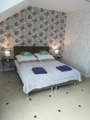 a bedroom with two beds with blue pillows at Apart-noclegi in Siemiatycze