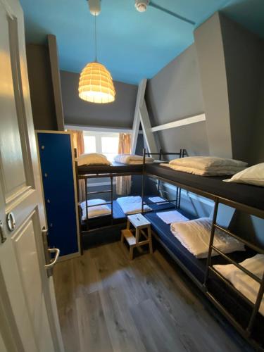 アムステルダムにあるホステル コスモス アムステルダムの二段ベッド4台と照明が備わる客室です。