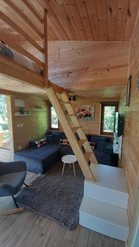 a living room with a staircase in a log cabin at Tiny House Grabovac in Rakovica