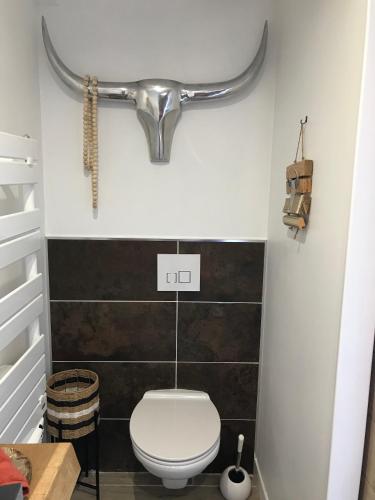 a bathroom with a toilet and a pipe on the wall at Entre Honfleur et Etretat in Octeville-sur-Mer