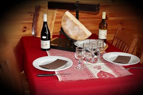 a table with two bottles of wine and wine glasses at Ô CHALET 1700 chalet FFS in Saint-Lary-Soulan