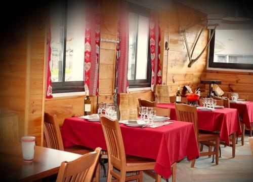 a dining room with tables and chairs with red table cloth at Ô CHALET 1700 chalet FFS in Saint-Lary-Soulan