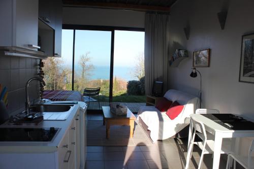 een keuken en een woonkamer met een groot raam bij Le petit Zeph in Varengeville-sur-Mer