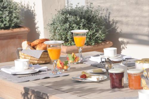 een tafel met brood en twee glazen sinaasappelsap bij Villa Vagabonde in Gordes