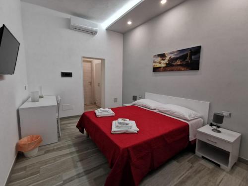 a bedroom with a red bed with a red blanket at B&B La Casa di Pino in Lampedusa