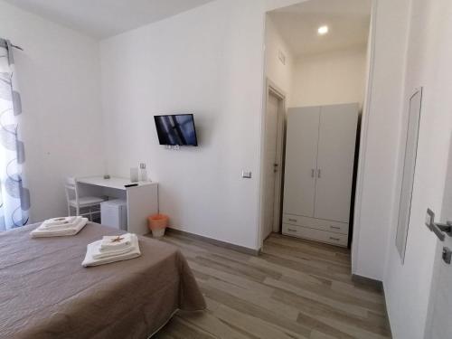 a bedroom with a bed and a tv on a wall at B&B La Casa di Pino in Lampedusa