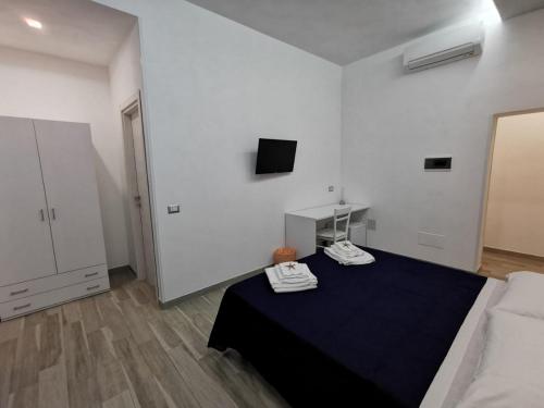a white room with a bed and a tv at B&B La Casa di Pino in Lampedusa