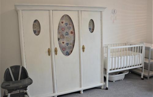 a white cabinet with two mirrors and a crib at Apartmány Pod vodárenskou věží in Poděbrady