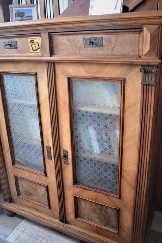 a wooden entertainment center with two glass doors at Apartmány Pod vodárenskou věží in Poděbrady