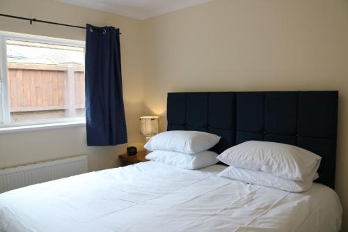 um quarto com uma cama com duas almofadas e uma janela em Goldcrest Cottage em Sandown
