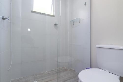 a bathroom with a toilet and a glass shower at CASA FRANK COM PISCINA EM MARISCAL in Bombinhas