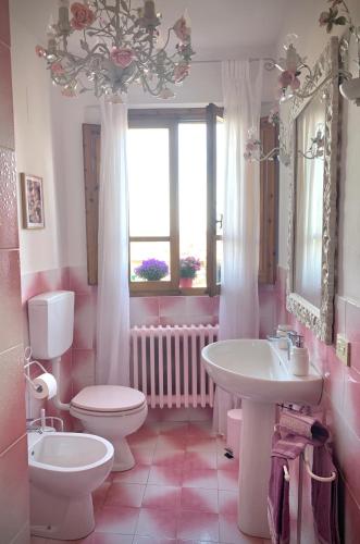 a pink bathroom with a toilet and a sink at Dolcevita Chianti Apartments in Radda in Chianti