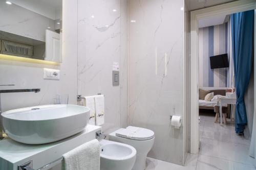 bagno bianco con lavandino e servizi igienici di Napoliviva Bovio a Napoli