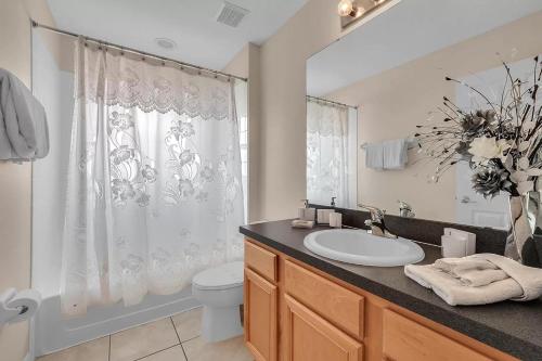 uma casa de banho branca com um lavatório e um WC em Share villa with other guests em Davenport