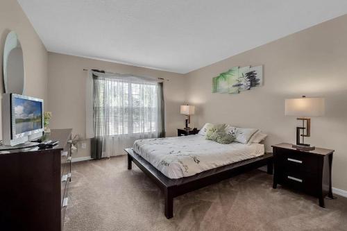 a bedroom with a bed and a flat screen tv at Share villa with other guests in Davenport