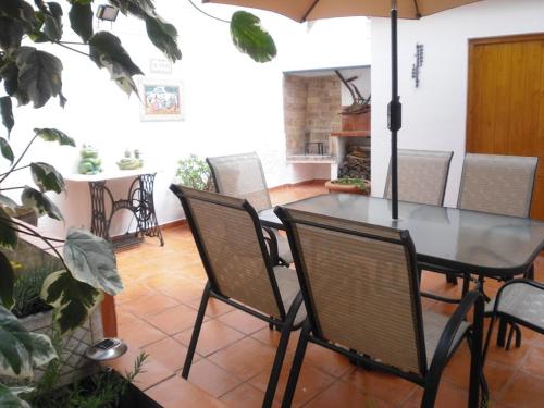 a dining room with a table and chairs with an umbrella at Cal Socías in Vilarrodona