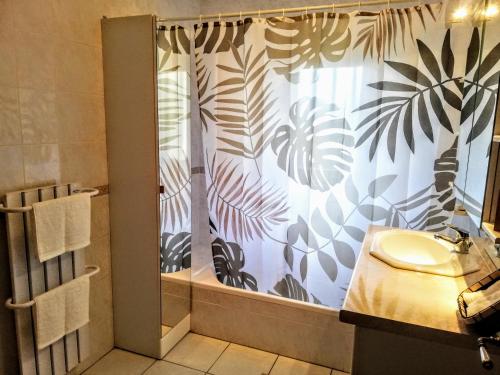 een badkamer met een douchegordijn en een wastafel bij Scandi-house in Marly-la-Ville