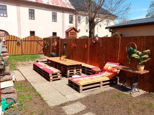 a backyard with a table and benches and a fence at chalupa in Hora Svatého Šebestiána