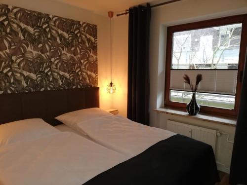 a bedroom with a white bed and a window at Apartment Enjoy in Büsum