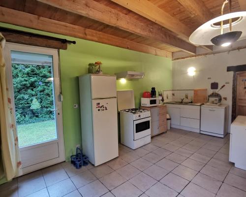 eine große Küche mit weißen Geräten und einem Fenster in der Unterkunft ferme de Méraville in Nielles-lès-Ardres