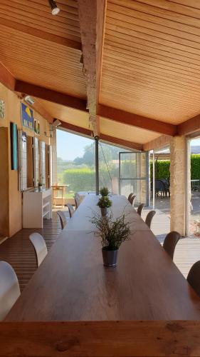 een grote houten tafel in een kamer met stoelen bij Le Jardin d'Ivana in Oppède