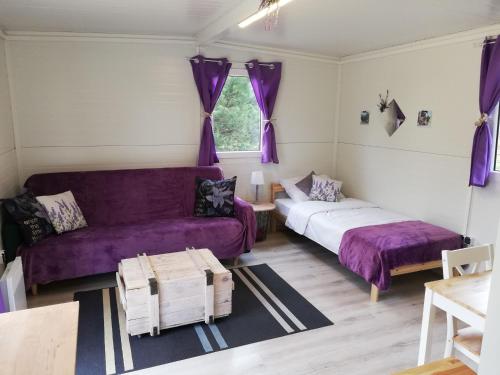a living room with purple furniture and a purple couch at Miodowy Zakątek Całoroczne Domki i Pokoje przy Suntago, Deepspot, Pyszne Śniadania, Grill in Mszczonów