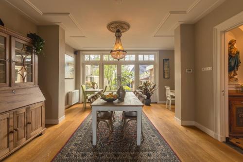 a dining room with a table and a chandelier at Pastorie Stella Marie in Oudeschild