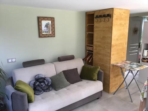 sala de estar con sofá y mesa en Villa des marronniers en Laudun