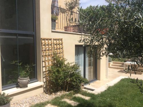 Casa con ventanas y balcón con plantas. en Villa des marronniers en Laudun