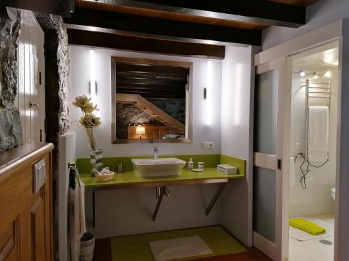 ein Badezimmer mit Waschbecken und Spiegel in der Unterkunft Casas de Pedra in Camacha