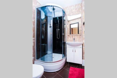 ein Bad mit einer Glasdusche und einem Waschbecken in der Unterkunft Квартира по ул. Смілянська, 2 (2-й этаж) in Tscherkassy