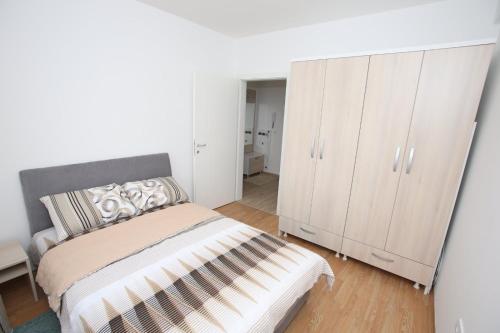ein Schlafzimmer mit einem Bett und einem weißen Schrank in der Unterkunft Fast Sleep & Go 3 in Paraćin