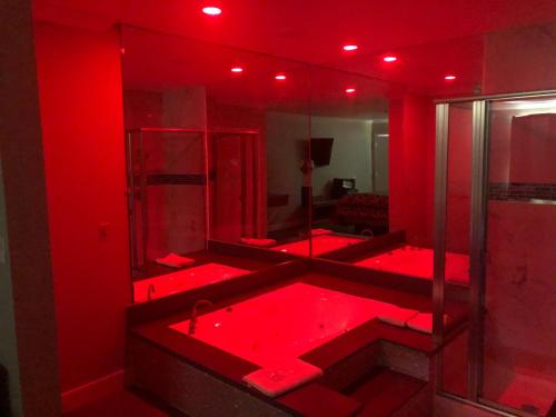 a red bathroom with a tub with red lighting at Economy Inn - Ontario Airport in Ontario
