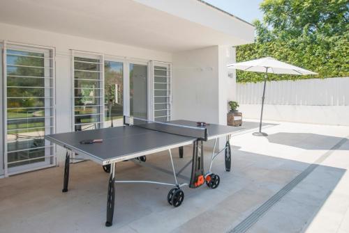 a ping pong table in front of a house at Villa Linda in Aldeia do Meco