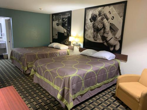 a hotel room with two beds and a couch at Super 8 by Wyndham Baytown I-10 in Baytown